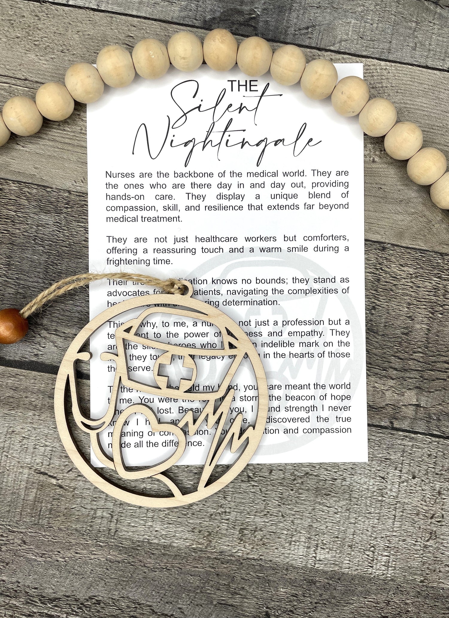 A printed card reading 'The Silent Nightingale' and wooden ornament is laid on a gray wood surface.