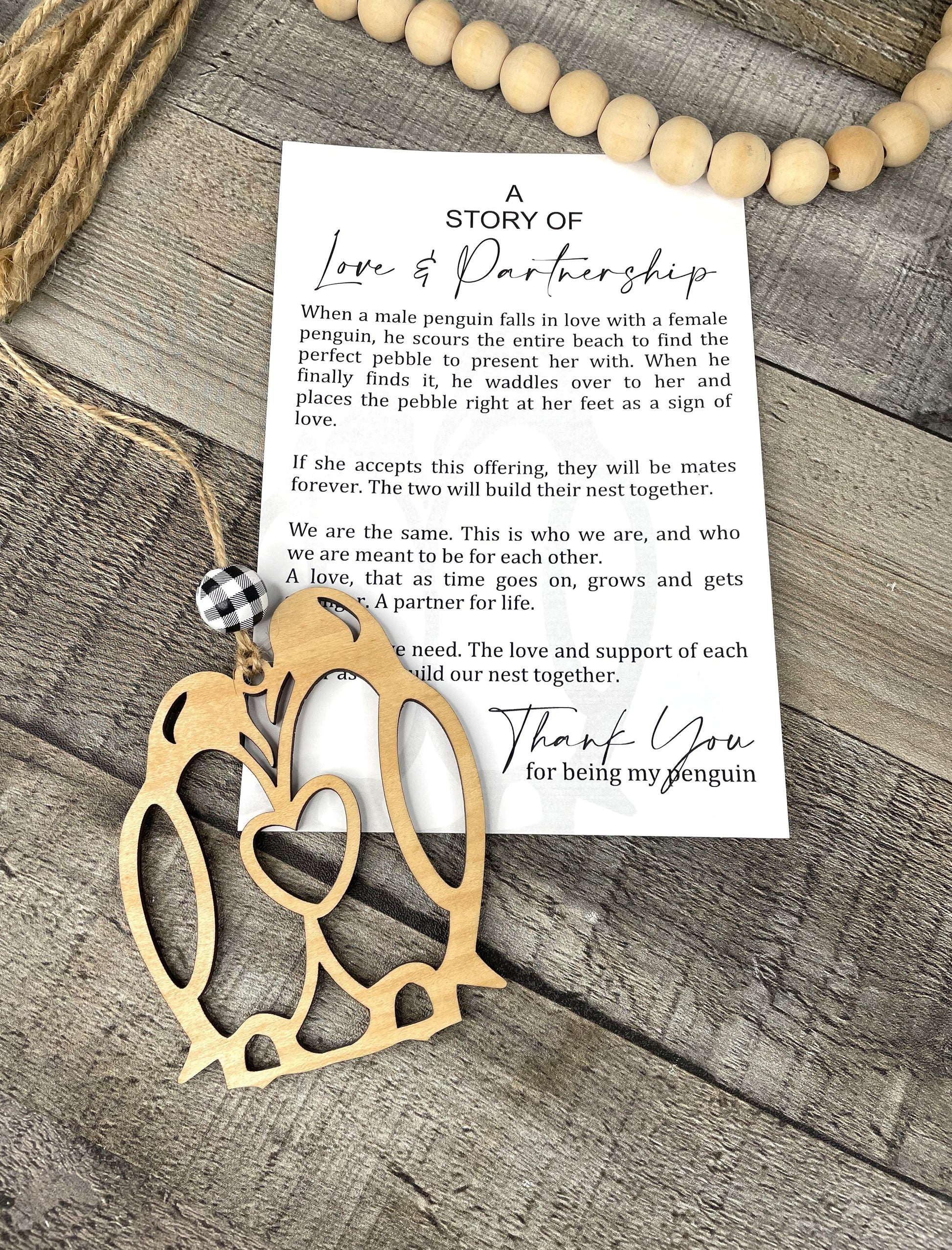 Wooden penguin ornament with a card on a wooden surface